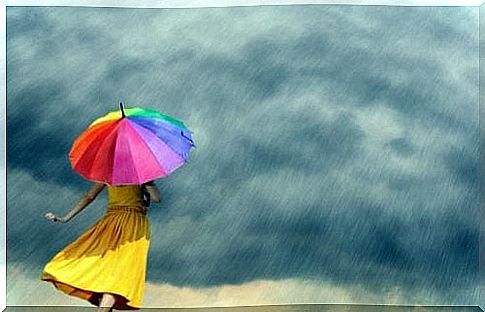 A woman with a colorful umbrella during a storm