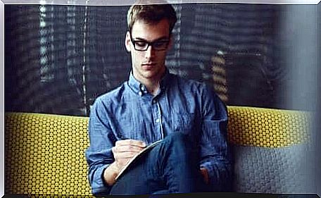 A guy sitting on the couch with glasses.