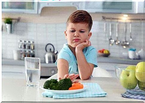 A child pushing away a plate.