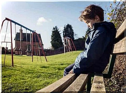 Children sitting alone on a bench in a playground