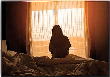 A woman looking out of her bedroom window.