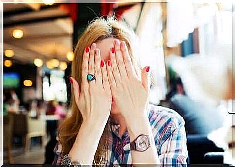 A woman with her hands in front of her face