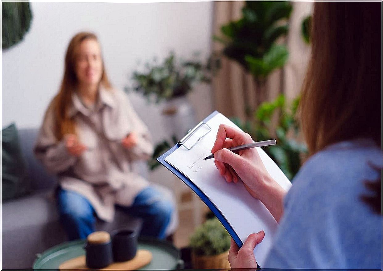 The psychologist writes down notes from the patient