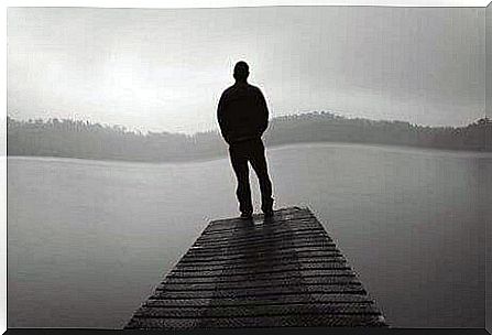 A man on a jetty in the fog