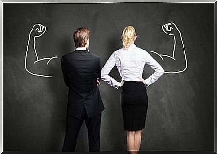 A pair in front of a blackboard with strong arms - The two sides of ambition