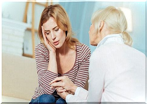 Two women talking together, one of whom looks very tired and worried