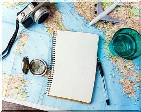 Notebook, compass and camera on a map