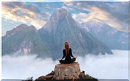 A woman meditating on the mountain.