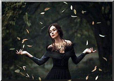 A woman with open arms makes a circle of leaves.